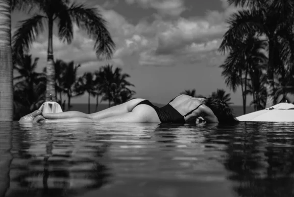 ヤシと青空とセクシーな女の子スイミングプール プールで日光浴女 — ストック写真