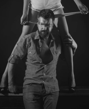 Baskın kadın, metres. Bacaklarıyla flört eden bir çift. Kırmızı kurdeleli çekici bir adam yüzünde şehvetli bacakları, baştan çıkarma ve tutku konsepti olan bir kadına selam veriyor.