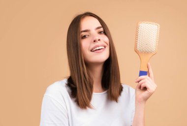 Saçlarını tarayan çekici bir kadın. Saçlarını tarayan güzel bir kız. Saç bakım konsepti