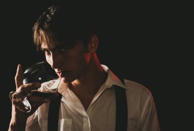 Pahalı bir içki. Gömlekli bir adam brendi ya da konyak içiyor. Bir bardak viskisi olan seksi genç adam. Sommelier 'in pahalı bir içki tadı var.