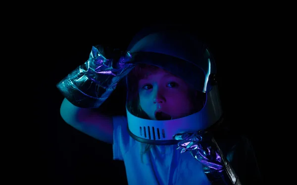 ヘルメットと保護宇宙服を着た小さな宇宙飛行士の肖像画 興奮した子供たちの顔をネオンカラーで閉じます — ストック写真