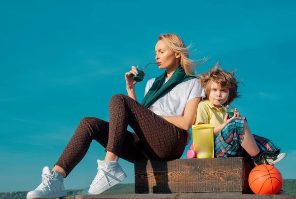 母亲和儿子运动后放松一下 穿着运动服的年轻女子在户外运动后喝着冰沙 健康蛋白质饮料 — 图库照片