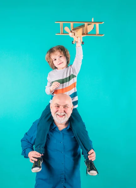 Grandfather and son piggyback with toy plane. Men generation granddad and grandchild