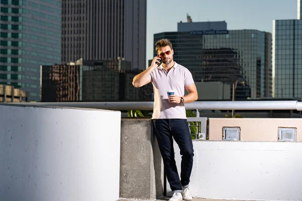 坦帕市的城市风格的家伙通过电话聊天 在美国城市里 一个穿着休闲装的有魅力的男人在电话中交谈的画像 英俊的年轻人在户外用电话 商务电话交谈 — 图库照片