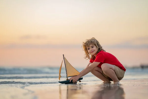 Little Blonde Boy Put Toy Boat Sea Waves Beach Summer — Stock Photo, Image