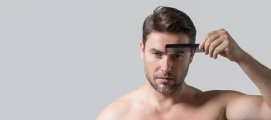 Başlık için afiş, erkek saç stili, saç kesimi için fotokopi alanı. Makasla orta yaşlı bir adam saç kesiyor. Erkek saç bakımı, güzellik berberi konsepti. Sakallı adam, elinde makasla. Makasla saç kes.