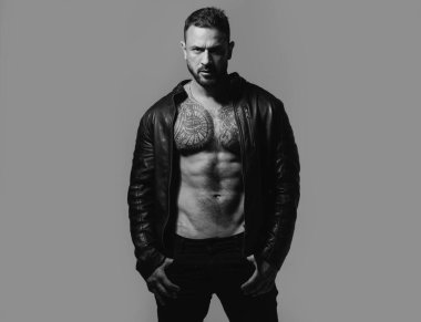 Acımasız bir adam, yakışıklı, ciddi bir erkek model. Güçlü kaslı erkek vücudu, kaslı adam. Üstsüz maço adam. Vahşi adamın moda portresi.