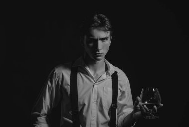 Viski, konyak, konyak içen bir adam. Degukasyon ve tatma. Bir bardak konyaklı adam. Bir bardak viskisi olan erkek model.