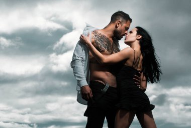 Gömleksiz, kaslı bir adam öpüşen kız arkadaşını kucaklıyor. Birbirine aşık genç bir çift. Seksi, tutkulu çift kucaklaşması. Duygusal çift stüdyoda birlikte poz veriyor. Yakışıklı Latin ve İspanyol aşıklar.