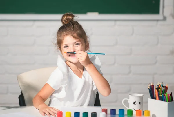 着色ペンで描く子供の女の子の絵 学校でアートやクラフトのレッスンを楽しみながら 喜んで笑顔愛らしい少女の肖像画 子供の創造的な教育の概念 — ストック写真