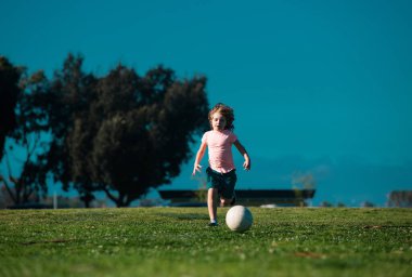 Futbolcu çocuklar, çocuk dışarıda futbol oynuyor. Futbolcu çocuk tekme atıyor. Futbol oyuncuları hareket halinde. Spor yaparken tatlı bir çocuk. Çocuklar futbol antrenmanı