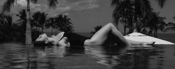 無限のプールでセクシーなエレガントな女性と青い海の上の景色をお楽しみください デザインヘッダー コピースペースのバナー — ストック写真