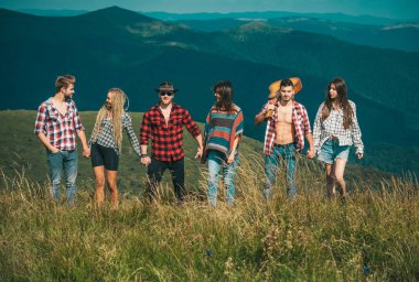 Dağlarda yürüyen bir grup hippi arkadaş. Kır yürüyüşü.