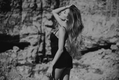 Yaz mankeni. Moda kadını dışarıda poz veriyor. Seksi elbiseli çekici genç kadın yazın tadını çıkarıyor.