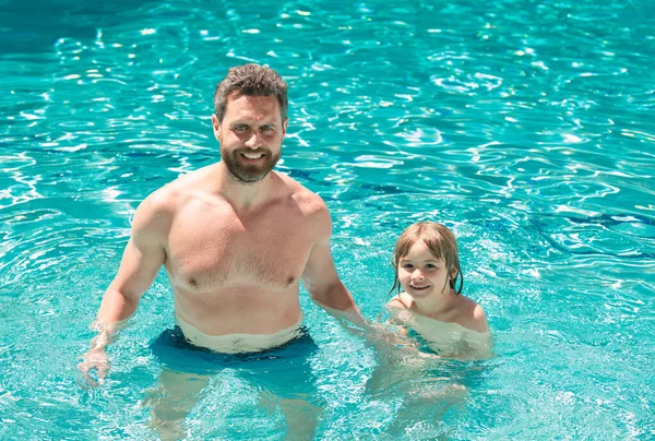 Father and son swimming in pool. Swimming lessons. Family summer weekeng. Dad and son in pool