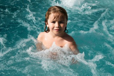 Yüzme havuzunda gülümseyen tatlı çocuk.