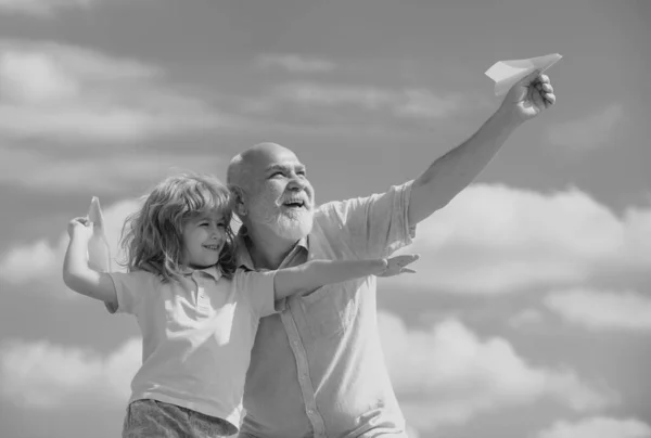 孙子孙女和祖父与玩具纸飞机在夏天的天空背景 梦想着飞翔的小男孩 — 图库照片