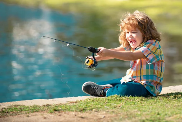 Child fishing. Young fisher. Boy with spinner at river. Portrait of  interested boy fishing at jetty with rod on the lake. Fishing concept.  Stock Photo by ©Tverdohlib.com 464887484