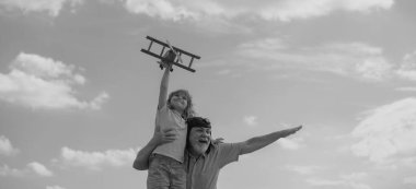 Mavi gökyüzü ve bulutların arkasında oyuncak uçakları olan dedem ve torunum. İki adam büyükbaba ve torunu dışarıda oynuyorlar.