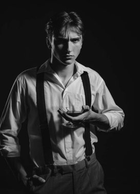 Adam cam brendi tutuyor. Genç adam konyak içer. Elinde bir bardak viski tutan adam