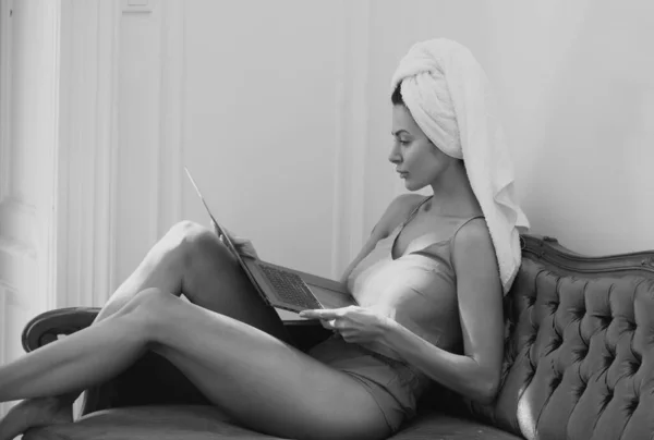 自宅でラップトップを使用してセクシーなビジネス女性 居心地の良い怠惰な朝 ベッドで寝た後の朝の美しい女の子 ソファの上のリラックスした女性モデル — ストック写真