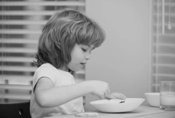 かわいい子供がスプーンで自宅でテーブルのそばで昼食を取るスープの食事や朝食を食べている肖像画 子供の健康食品 — ストック写真