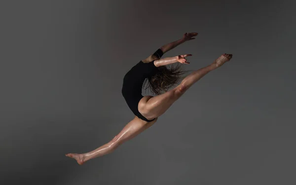 Прыжок Ногой Вниз Гибкое Сексуальное Тело Молодой Женщины Черном Фоне — стоковое фото