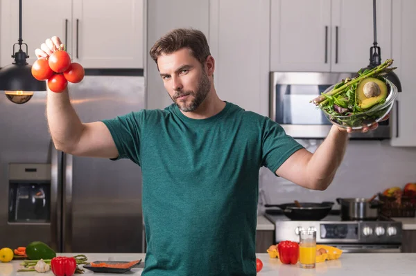 キッチンの自宅で新鮮な自然減量の食事を準備魅力的な男の肖像画屋内 台所で食事を準備するハンサムな陽気な男 健康食品 料理のコンセプト — ストック写真