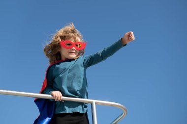 Mavi gökyüzü arka planına karşı süper kahraman çocuk portresi. Uzayı kopyala Çocuk süper kahraman