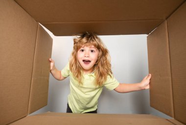 Çocuk bir kutu açıyor ve içine bakıyor, paketleri açıyor, sürpriz bir şekilde boks yapıyor. Paketleme veya açma kavramı
