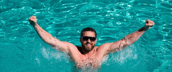 Happy man in swimming pool. Summertime vacation. Summer man. Pool resort. Guy in water