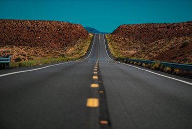 Turuncu taşlı manzara, bulutlu gökyüzü ve yazın asfalt yol..