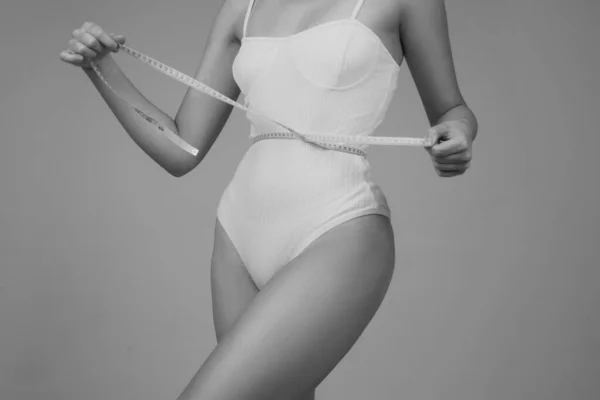 ウエストラインの周りのテープを測定するスリム女性 フィットフィットネスガール測定テープでウエストラインを測定します 食事の後に腰を測定スリム女性 スリムな体 完璧な腰 — ストック写真