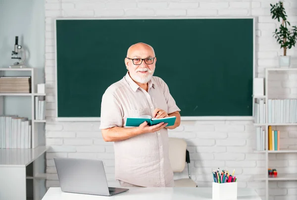 男人成熟的老师 高中或大学时 戴眼镜 在黑板上看书的聪明的高中导师的画像 退休的男教师 上大学时的老学生 — 图库照片