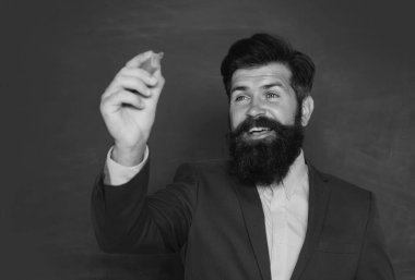 Portrait of a funny teacher or professor near blackboard. Thinking serious mature teacher. Mature professor, middle aged teacher, bearded man. Teachers day