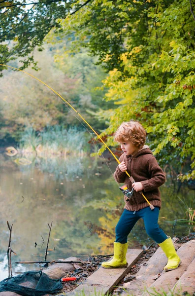 小さな男の子釣り 週末に釣りをしながらロッドを引っ張る子供 — ストック写真