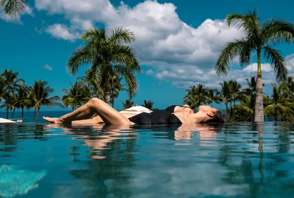 Lüks Bir Tatil Köyünde Sonsuz Yüzme Havuzunda Güneşlenen Bir Kadın — Stok fotoğraf