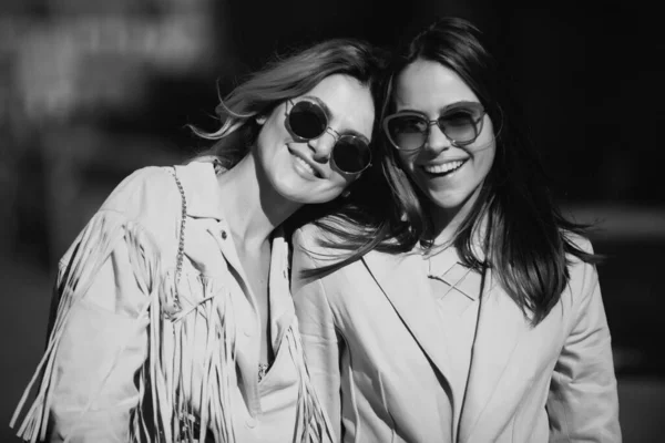 Portrait of two women, laughing girls friends in sunglasses outdoor