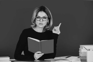 Üniversitede ya da lisede masada çalışan öğretmen ya da kadın öğretmenin portresi. Sınıfta okuyan genç bayan öğrenci. Konsept çalış