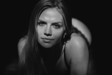 Şehvetli kadın yüzü. Stüdyoda siyah arka planda güzel, ince bir kadın.