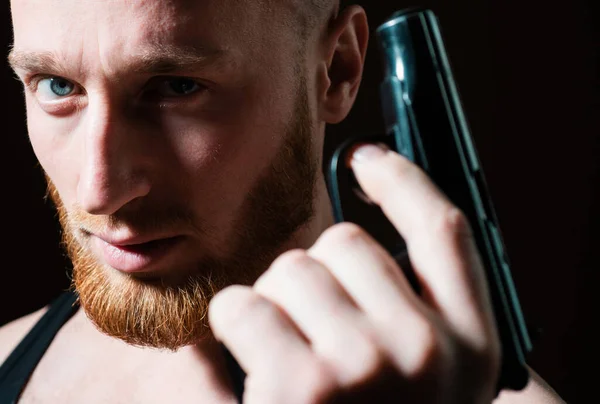 ギャングの仕業だピストル銃を狙う殺人者 閉じる上の男の肖像画とともに深刻なプロフィール顔 — ストック写真