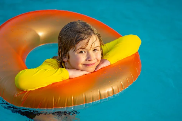 水泳プールで屋外で夏休みを楽しむ幸せな子供 水着を着たかわいい子供がインフレータブルリングでリラックスしています プールに浮かぶ子供 — ストック写真