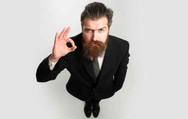 Tamam imzası olan bir işadamı. Takım elbiseli komik, yakışıklı iş adamı geniş açılı. Gömlekli çekici bir iş adamı. Olgun sakallı bir iş adamının portresi.