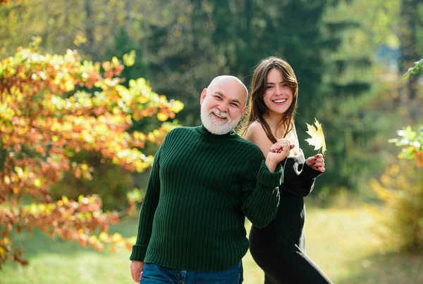 孙女和年长的祖父站在秋天的公园里 有爱心的成年女儿和老爹呆在一起 — 图库照片