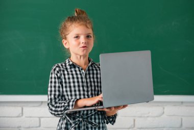 Laptop kullanan neşeli öğrenci portresi. Çocuk eğitimi, okul teknolojisi