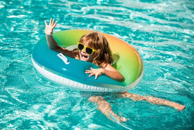 Yaz tatili. Yaz çocukları hafta sonu. Aquapark 'ta şişme lastik çemberde yüzen komik çocuk.
