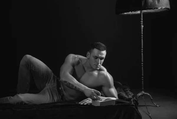 寝室で読書中の男 ベッドの中で裸のマシン セックスとリラクゼーションの概念 本好き 贅沢な生活 — ストック写真