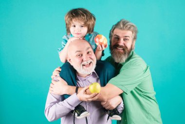 Baba, oğul ve büyükbaba mutlu bir aile. Mutlu yıllar, çok nesilli erkekler. Büyükbaba baba baba ve çocuk torun sarılıyor ve gülümsüyor.