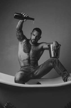 Lüks elit eğlence. Lüks hayatı şampanya şişesi ile kavramı. Acımasız adam, banyo içine dökülen şampanya ile. Lüks hayat. Lüks elit alkol ile çekici erkek