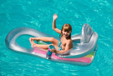 Yaz zamanı. Yaz tatili. Yüzme havuzunda bir çocuk. Aquapark. Şişme lastik yatakta mutlu çocuk.